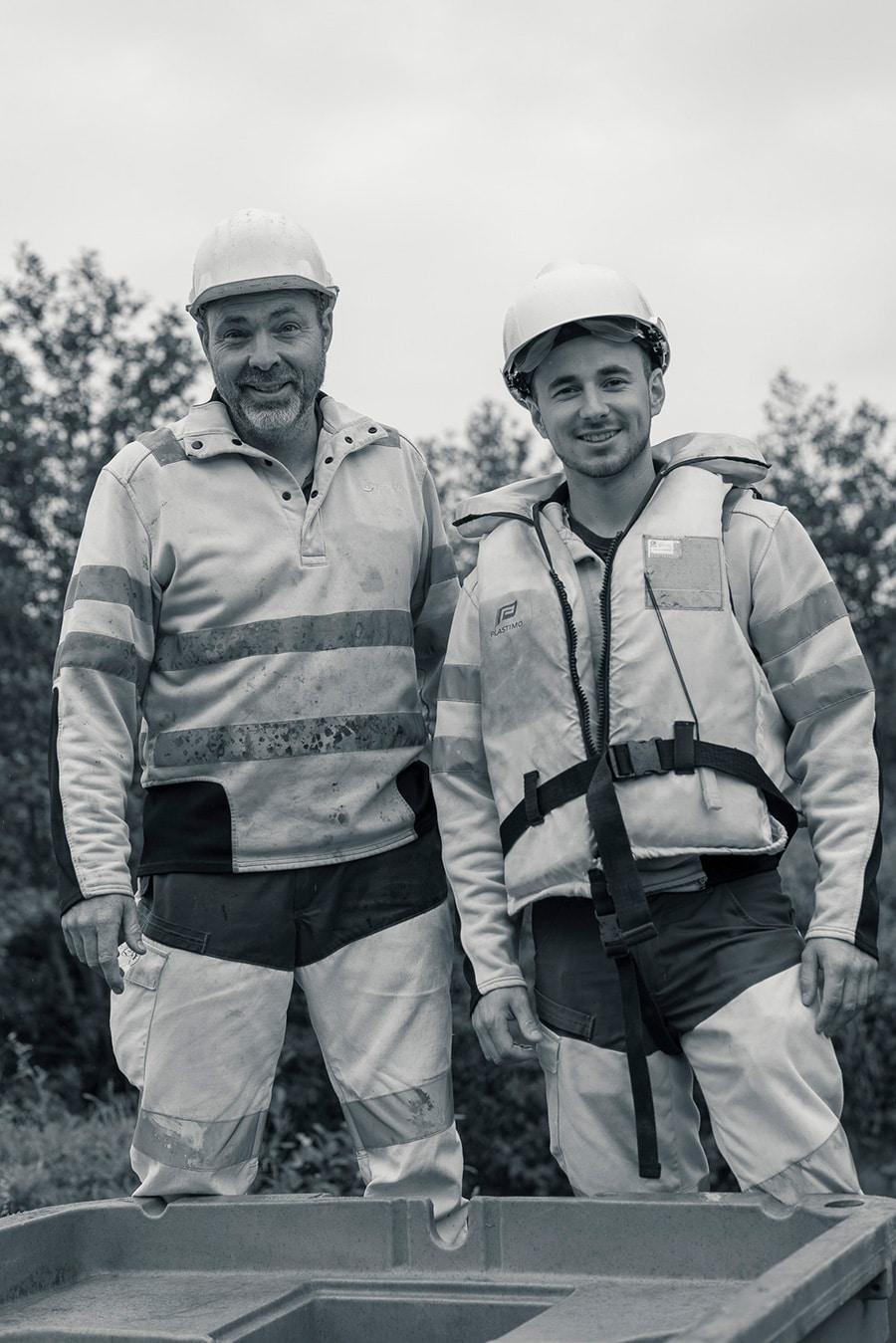 Image de deux membres du SMAEL vêtus de leurs uniformes de travail, souriants devant l'objectif de l'appareil photo.
